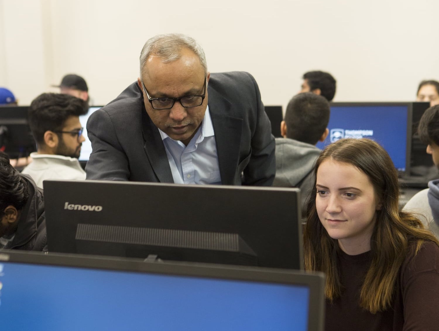 Teacher and student looking at computer